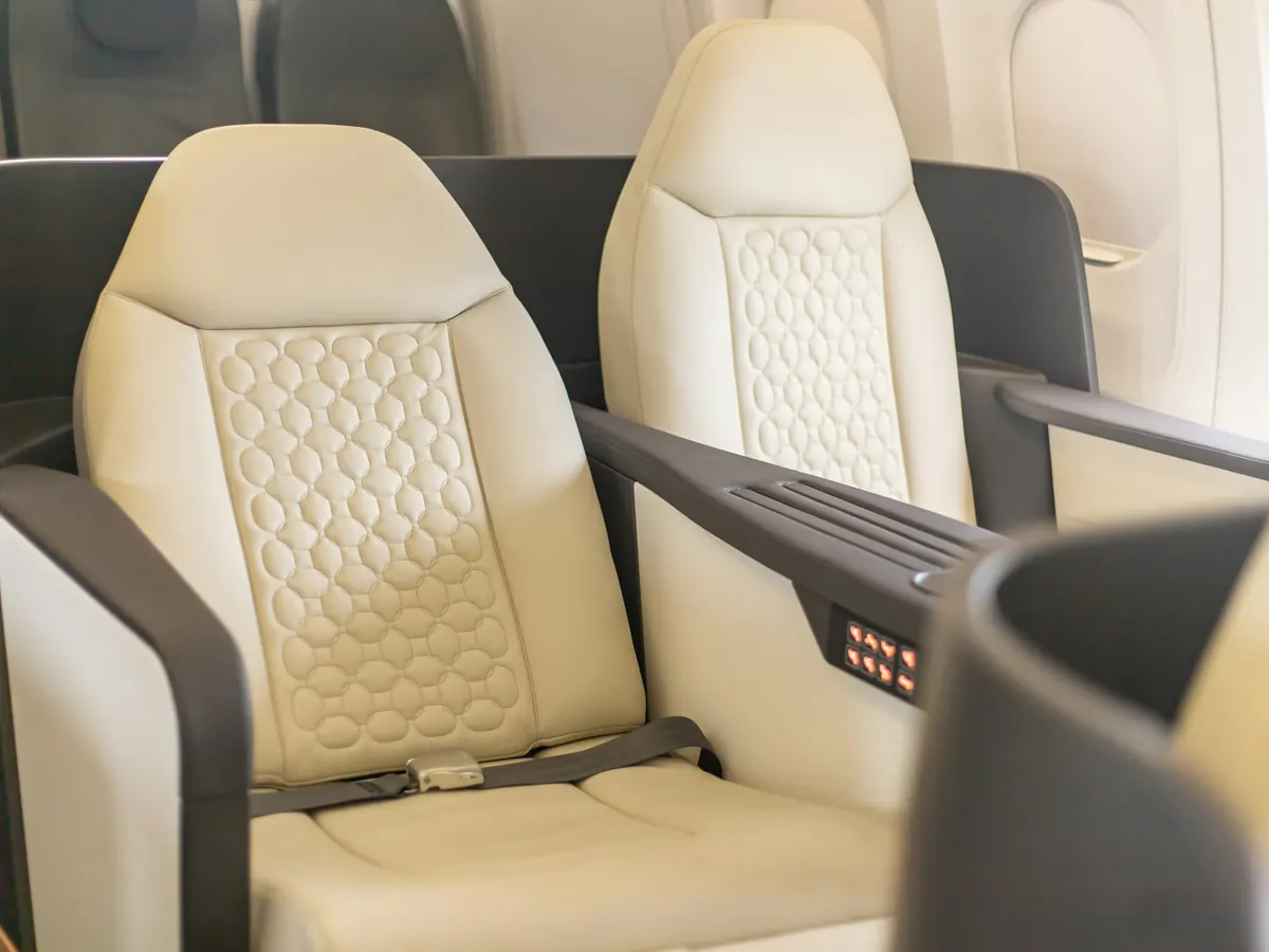 Cream leather seats facing each other in a jet cabin
