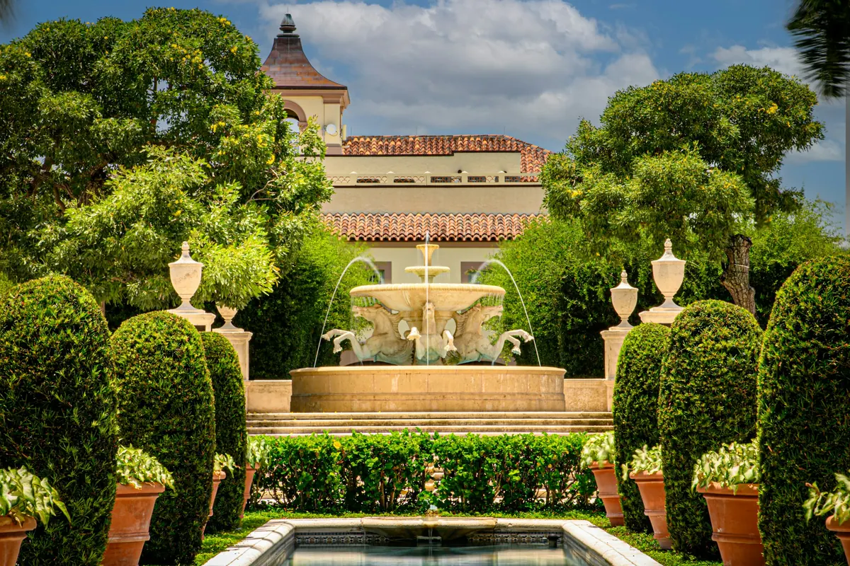 Palm Beach hotel garden with a fountain and clipped hedges