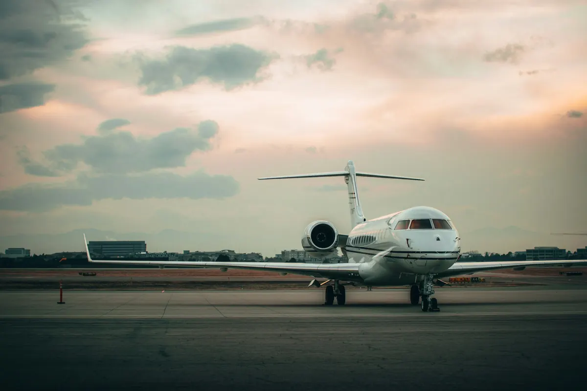 Long-range business jet parked on a ramp at dusk